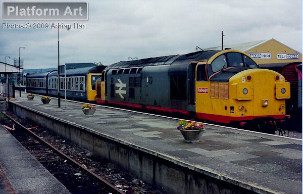Railfreight liveried Class 37 37032 hauls failed Class 108 DMU set S943 out of Carmarthen station on 28th July 1989.